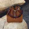 Borsa a secchiello Bon Bon in pelle scamosciata color cuoio con chiusura a perline e manico tartarugato Borsa a secchiello Bon Bon in pelle scamosciata color cuoio con chiusura a perline e manico tartarugato
