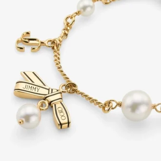 Bracciale con nastri e ciondoli multipli Bracciale in metallo dorato con ciondoli, nastri e perle Bracciale con nastri e ciondoli multipli Bracciale in metallo dorato con ciondoli, nastri e perle