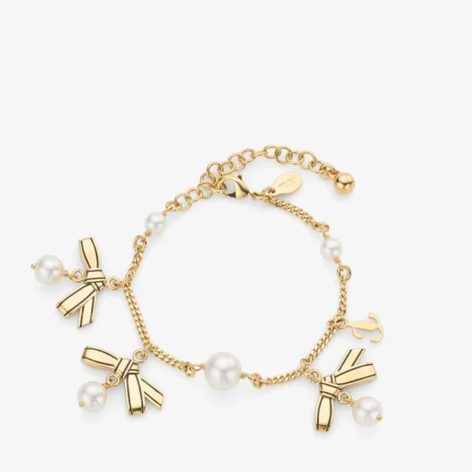 Bracciale con nastri e ciondoli multipli Bracciale in metallo dorato con ciondoli, nastri e perle Bracciale con nastri e ciondoli multipli Bracciale in metallo dorato con ciondoli, nastri e perle