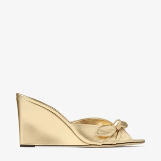 Livi Wedge 85 Mules con zeppa in nappa metallizzata dorata con fiocco