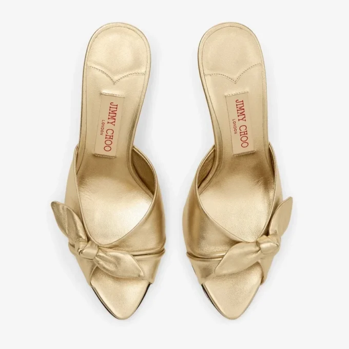 Livi Wedge 85 Mules con zeppa in nappa metallizzata dorata con fiocco Livi Wedge 85 Mules con zeppa in nappa metallizzata dorata con fiocco