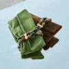 Pochette Zandra in pelle scamosciata color trifoglio con bracciale di perline Pochette Zandra in pelle scamosciata color trifoglio con bracciale di perline